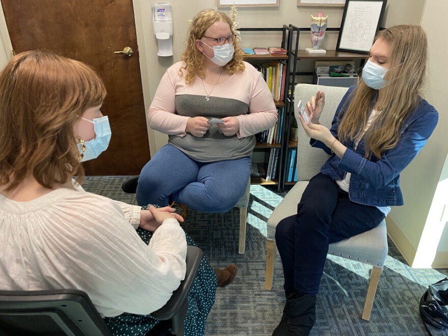 Speech-language pathologist Taylor Adams leads a small group session. Her groups usually contain six individuals. The women practice vocal exercises and play word games.