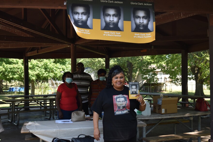 Gloria Clark-Jackson holds up a copy of her book during a signing event on Sept. 5, 2020 at Martin Luther King Jr. Park in Peoria.