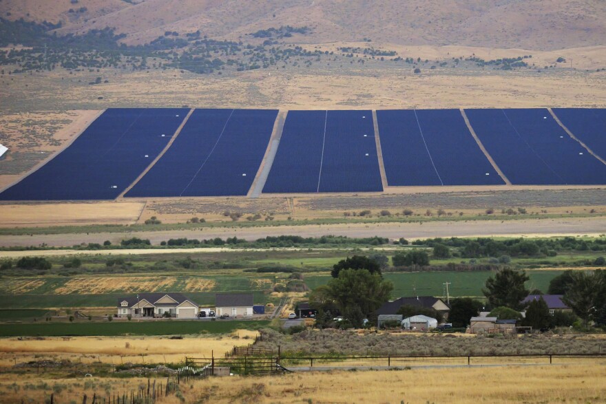 A solar farm sits behind homes Tuesday, Aug. 9, 2022, in Mona, Utah. The U.S. has renewed credibility on global climate issues and will be able to inspire other nations in their own efforts, experts say, after the Democrats pushed their big economic bill through the Senate on Sunday, Aug. 7. (AP Photo/Rick Bowmer)