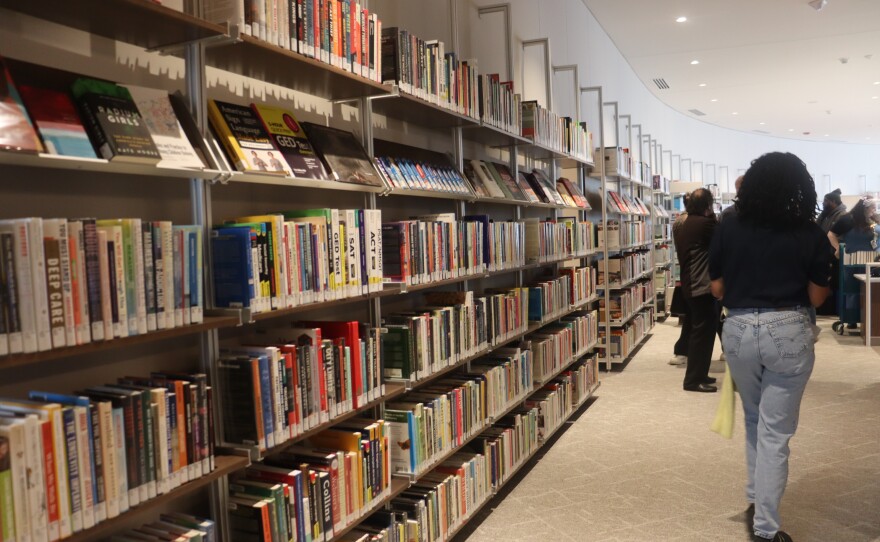 A wall of bookshelves filled with books on the upper level of the Portland Library