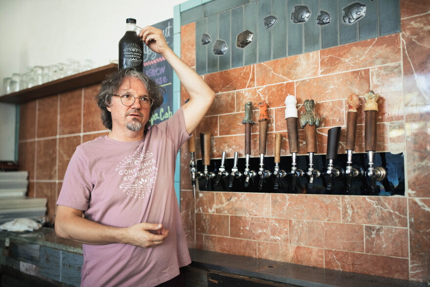 Confluence Kombucha owner William Esslinger attempts to balance a bottle of huitlacoche and shiso leaf kombucha on his head on Aug. 26 at his kombucha brewery in Fox Park.