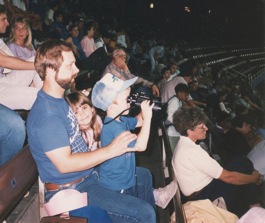An image of young Erik Mertens with his sister and dad at a Mariners game in the old Kingdome.