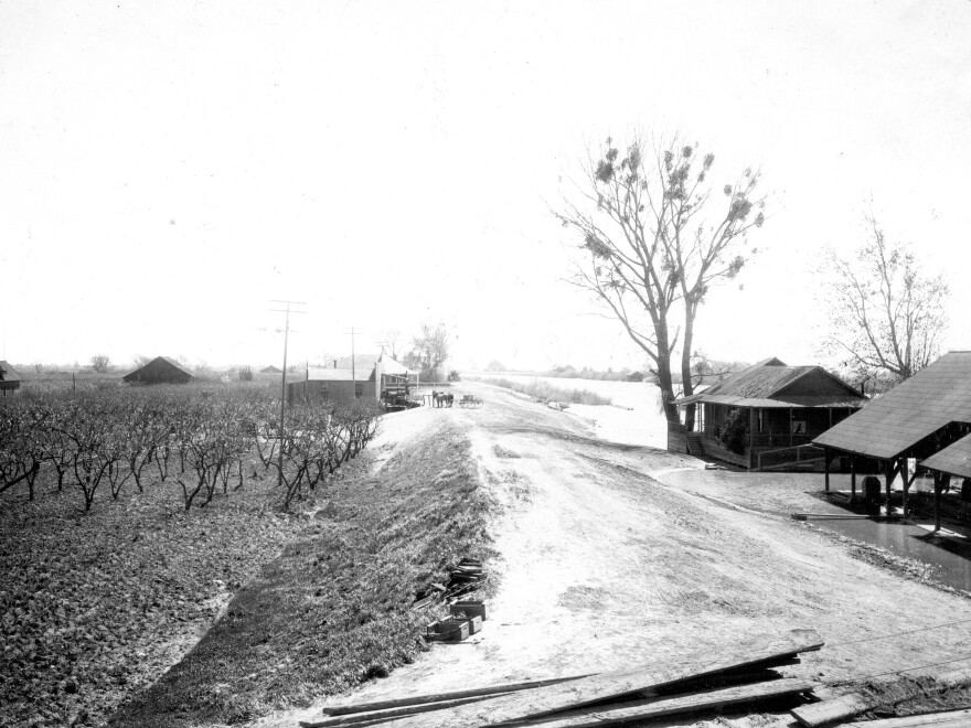 A man-made levee separates a settlement in the delta from the Sacramento River in 1906.