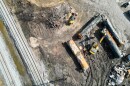 Aerial view of damaged trains laying in dirt beside the train tracks in East Palestine
