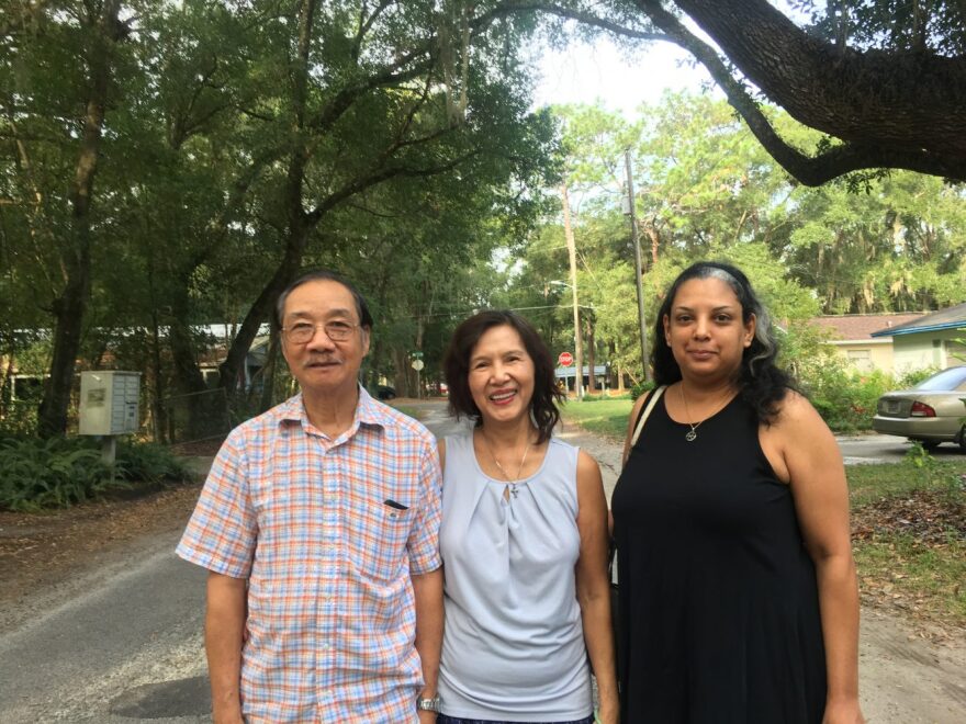 Hong Nguyen, Thuan Ho Nguyen and Wendy Dematas-Palmer, neighbors on Northwest 31st Place, have been unhappy with their street's condition for years. (Lauren Johnson/WUFT News)