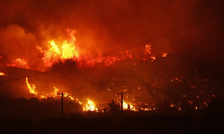 A wildfire burns next to power lines near Othello, Wash., early Sunday, Aug. 13, 2017. 