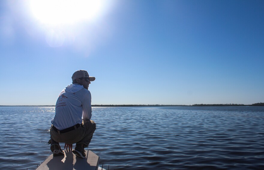 Szatkowski crouches at the bow of his boat Sheila in August 2025. (Rylan DiGiacomo-Rapp/WUFT News)