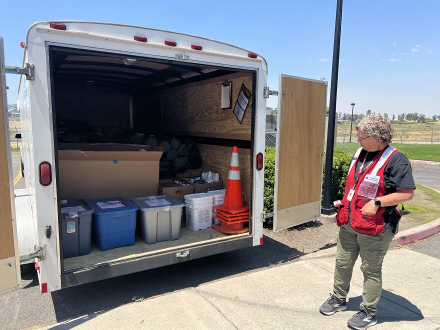 Shelter supervisor Katrina Long stands behind a Red Cross truck filled with emergency supplies for the Eagle Point Middle School evacuation shelter.