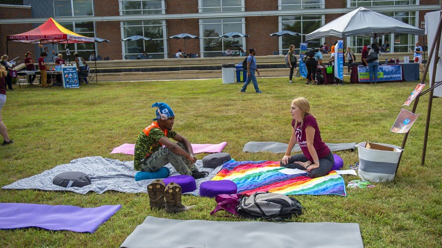 Two people sitting on blanket at event