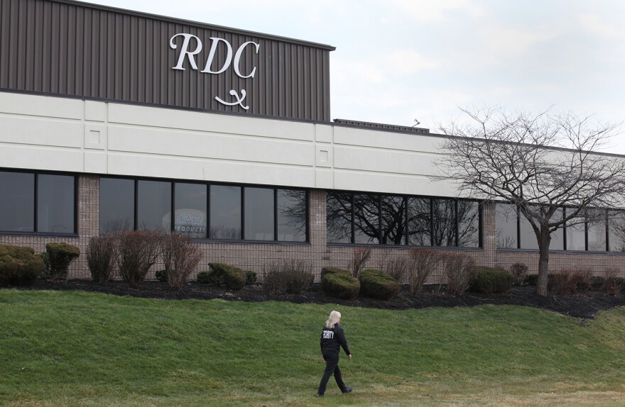 A woman in a security uniform walks the grounds of Rochester Drug Cooperative in Chili Tuesday afternoon after the company announced it will no longer distribute controlled substances.