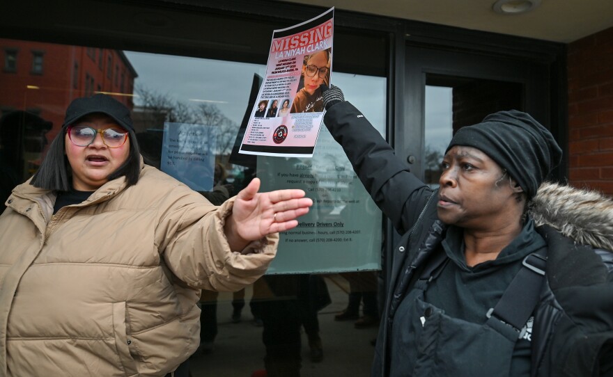 Candace Lowe talks to the press about the adoptive family of La'Niyah Clark while her adoptive grandmother, Carmen Tinson, holds La'Niyah's missing poster.