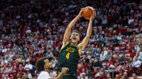 Gavin Doty (4, Green) skies for a rebound in Siena's 81-60 loss at Indiana on December 22, 2025. Doty, who averaged 18 points for Siena last season, announced Tuesday his transfer to Syracuse.