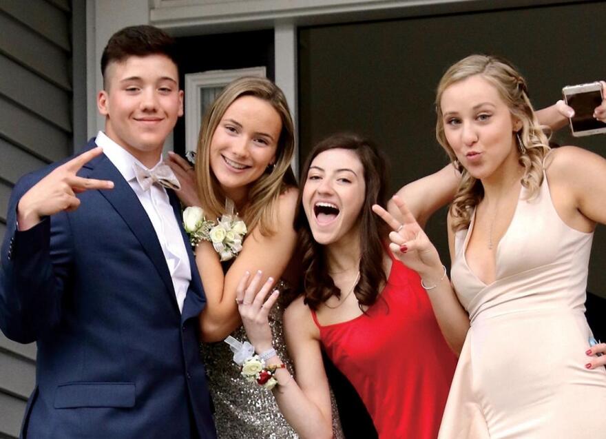 Four teenagers in prom clothes.