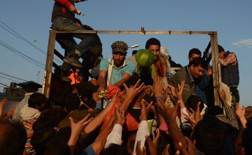 Kashmiri volunteers distribute food to residents affected by flooding in Srinagar on Sunday. Fresh rain hampered rescue operations a week after deadly floods swamped the Himalayan region.