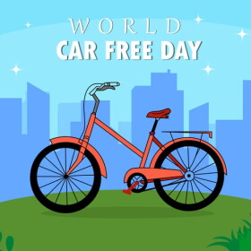 illustration of a bicycle on a green hill in front of a cityscape with the words WORLD CAR FREE DAY over the top 