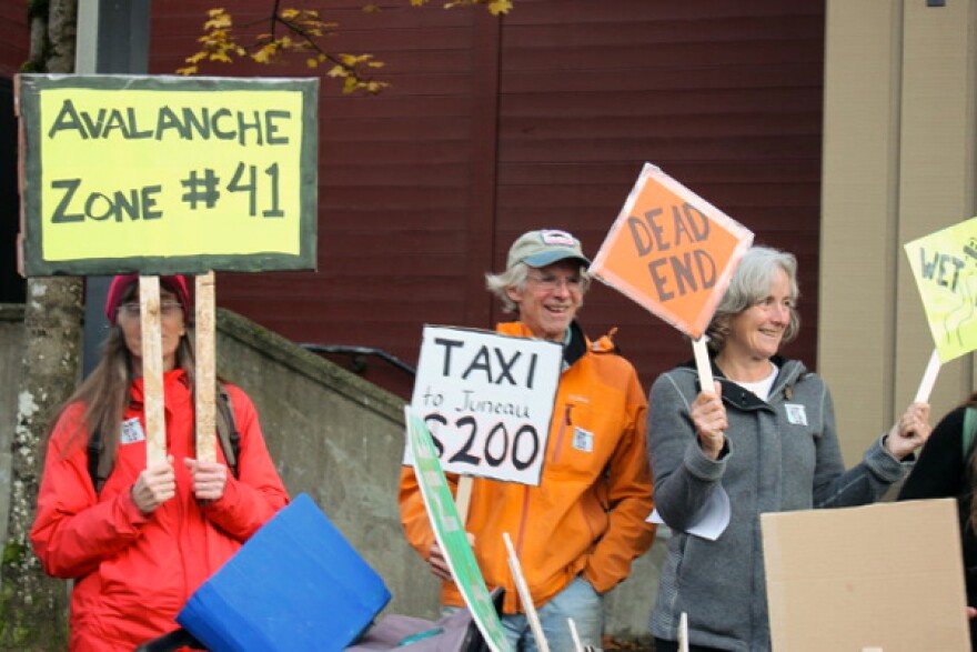 A few dozen people participated in a rally the Southeast Alaska Conservation Council organized outside Centennial Hall. They were supporting ferries and opposing an extension of the Juneau’s main road. (Photo by Jennifer Canfield/KTOO)