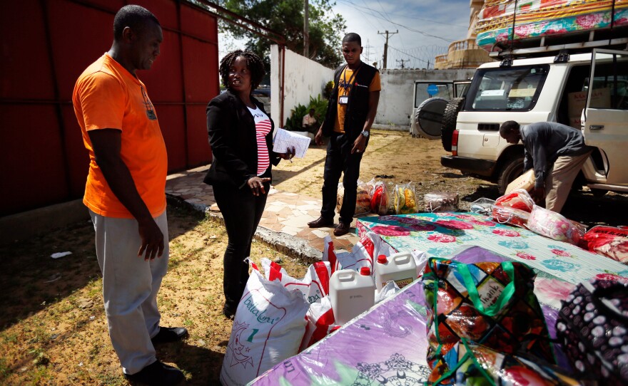 Sienna Wisseh of Liberia's Family Welfare Division (center) directs the packing of supplies that will be given to families adopting or reuniting with children.