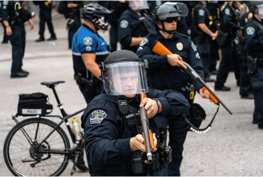 Austin police officer Justin Berry holds a weapon with so-called less-lethal rounds during a protest in front of Austin City Hall on May 31, 2020. The protesters gathered in response to the murder of George Floyd by a Minneapolis police officer.