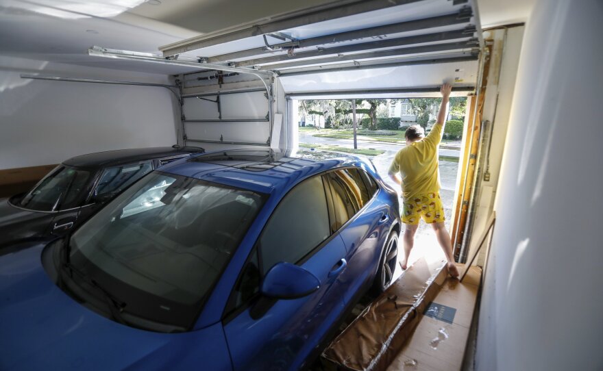 Max Ceratti, 19, lifts up the garage door to examine the damage done to his car from Hurricane Helene at his home around the Sunset Park neighborhood on Friday, Sept. 27, 2024, in Tampa, Fla. (Jefferee Woo/Tampa Bay Times via AP)