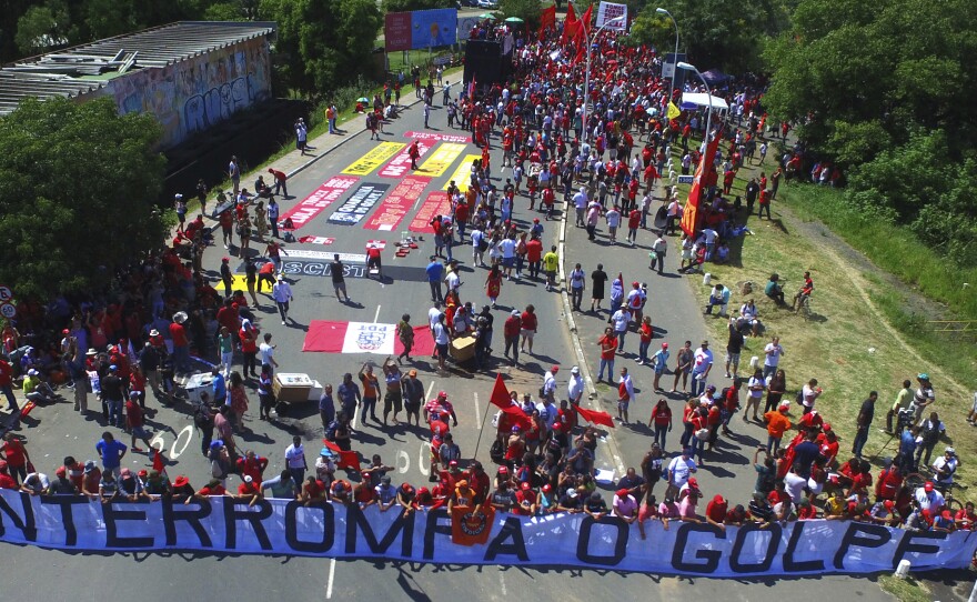 Lula's supporters hold a banner that reads, in Portuguese, "Stop the Coup." The demonstrators had gathered Wednesday near the court in Porto Alegre, Brazil, where judges ruled unanimously to uphold the former president's graft conviction.
