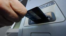 A person inserts a debit card into an ATM. (Gene J. Puskar/AP)