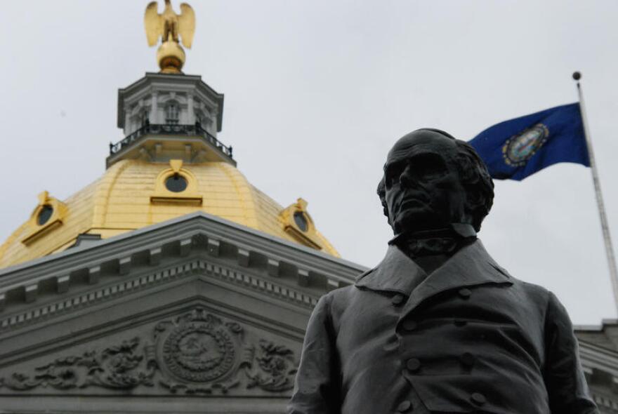 State House dome with a statue and flag in the foreground