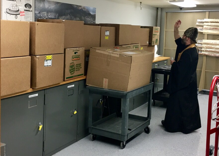 Father Innocent Dresdow performs service on the remains in the room where they’re being kept, in a lower level of the Alutiiq Museum. (Photo by April Laktonen Counceller / Alutiiq Museum)