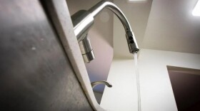 Water flows from a kitchen faucet into a sink.