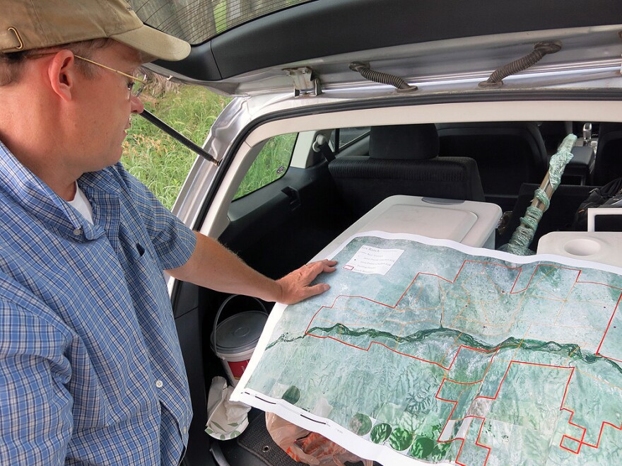 Ecologist William Burnidge checks a map of Fox Ranch that details the different areas rancher Nathan Andrews can graze his cattle.