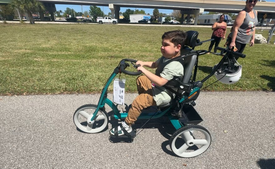 Marcel Rodriguez is 11 years old. He takes off on his new bike from Robbie’s Riders, Grampy’s Charities and Sanibel Captiva Community Bank. The three sponsors presented custom-made, adaptive bicycles and tricycles to local special needs children. Eight adaptive tricycles, worth nearly $3,000 each, were given out on Friday, March 20, 2026. Marcel has Duchenne muscular dystrophy, a genetic disorder that causes progressive muscle weakness.