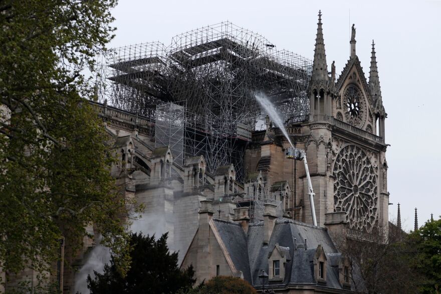 Firefighters spray water as they work to extinguish a fire at Notre Dame Cathedral in Paris early on Tuesday. A huge fire that devastated Notre Dame Cathedral is "under control", the Paris fire brigade said after firefighters spent hours battling the flames.