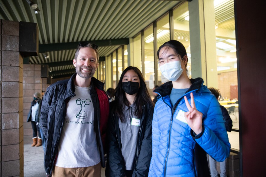 Photograph of Wilson Skinner and two-thirds of his Francisco Middle School chess team, including Vicky Lee. Lee credits Chess.com and the club visits for helping her practice.