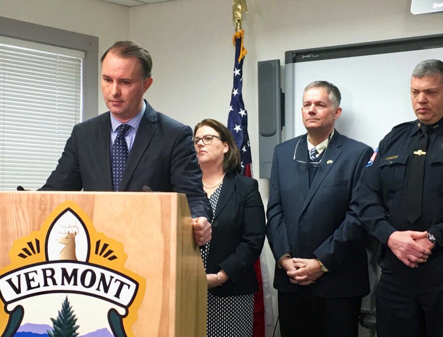 TJ Donovan stands at a podium with people behind him.