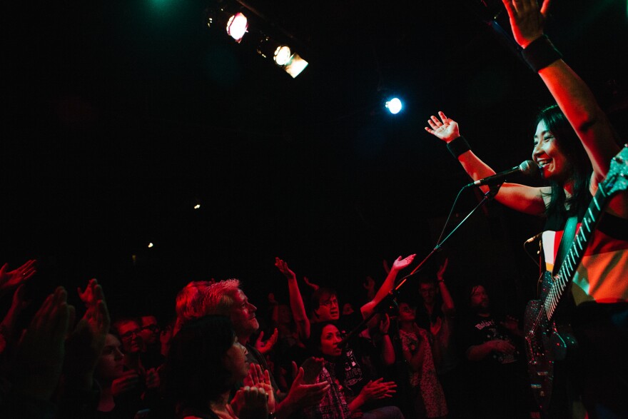 Naoko leads the crowd in a clapping beat at D.C.'s Black Cat, where the band played to a packed room.