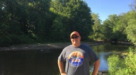 Brad McBride, of Burning River Adventures, stands near the banks of the Cuyahoga River. (Elizabeth Miller/WCPN)