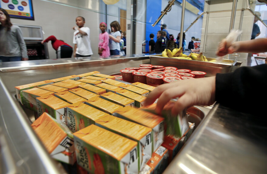 Students at Jardine Elementary School pick up apple juice, apple sauce or a banana to go with their lunch. [Chris Neal/Shooter Imaging]