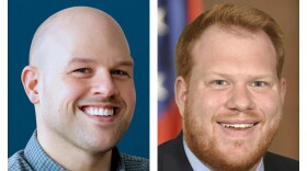 A joined photo of two smiling men: The photo at left includes a bald man wearing a blue checked button-down shirt; the photo at right includes a red-haired man with a red mustache and beard wearing a white button-down shirt, a red tie with blue and white stipes, black suitcoat, and an American flag lapel pin