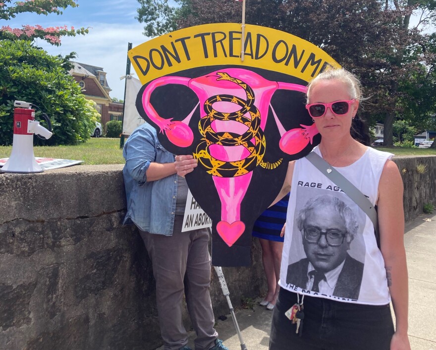 A protestor in New Bedford on Friday holds a sign that blends symbols from the Gadsden flag with a drawing of the female reproductive system. The U.S. Supreme Court ruled 6-3 in a case that overturns Roe v. Wade.