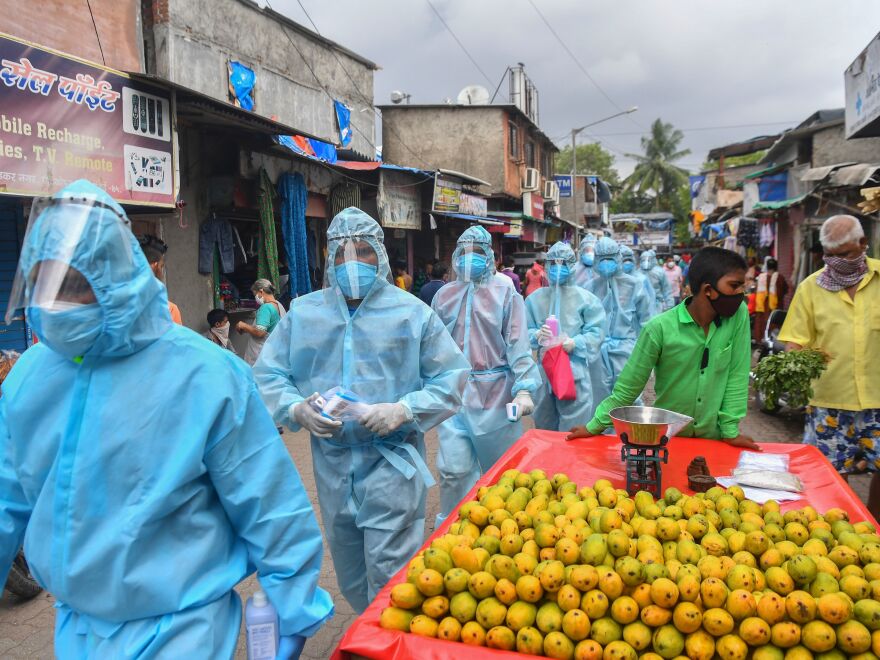 Medical staff along with Hindu hardline group Rashtriya Swayamsevak Sangh (RSS) volunteers walk through a market for a door-to-door medical screening in Mumbai on June 17, 2020.