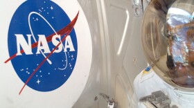 Astronaut Robert L. Curbeam Jr., STS-116 mission specialist, meets the NASA logo up close during the Dec. 14 space walk to perform ISS work, which he shared with European Space Agency astronaut Christer Fuglesang.