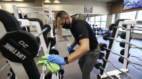 Jason Nichols, facilities operation manager, disinfects equipment at the Life Time Biltmore as it opens for business after being closed due to the coronavirus Monday, May 18, 2020, in Phoenix.