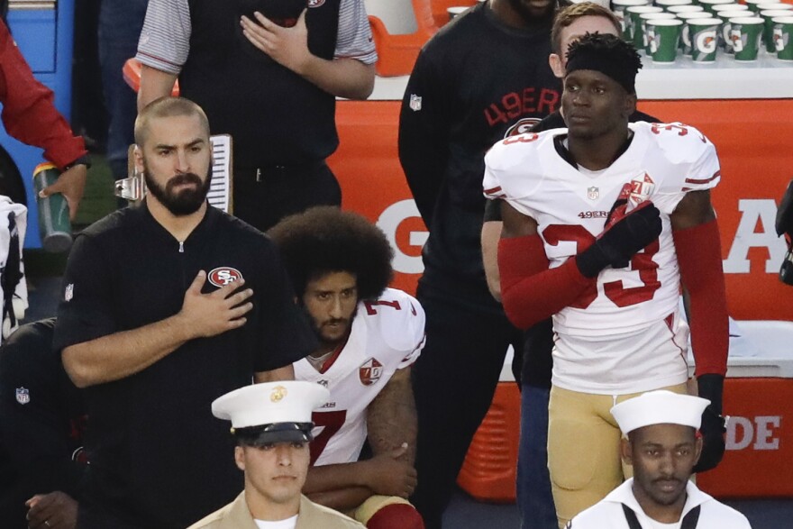 In this Thursday, Sept. 1, 2016 file photo, San Francisco 49ers quarterback Colin Kaepernick, middle, kneels during the national anthem before the team's NFL preseason football game against the San Diego Chargers. (Chris Carlson/AP)