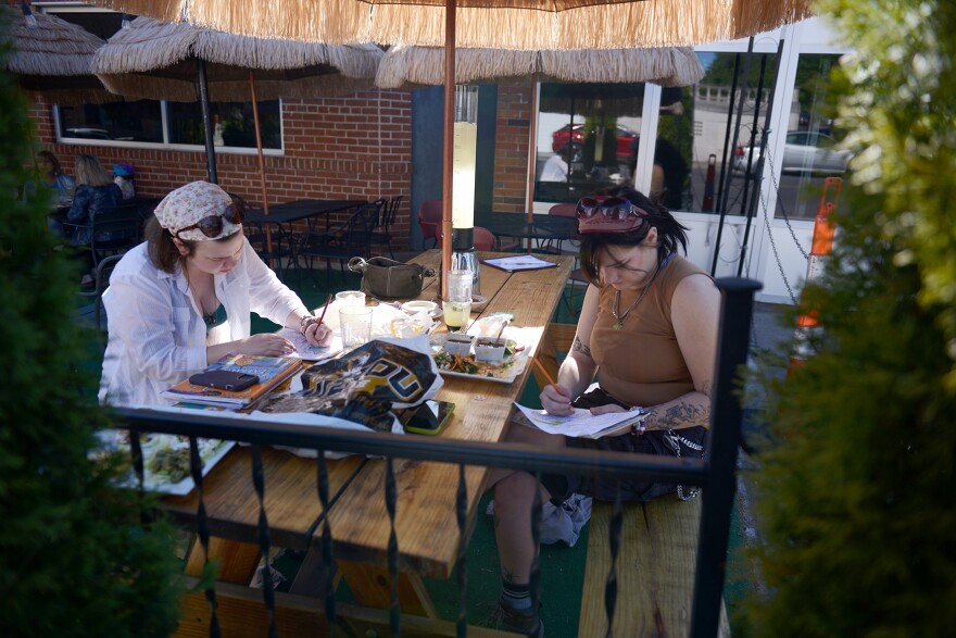 Kelaiah Killmade, left, and Claire Eile, right, eat dinner and draw in coloring books on Wednesday, May 3, 2023, at El Oso Mexican Grill in Columbia. Eiler said she and Kill are “good buds” and have been friends for more than a year.