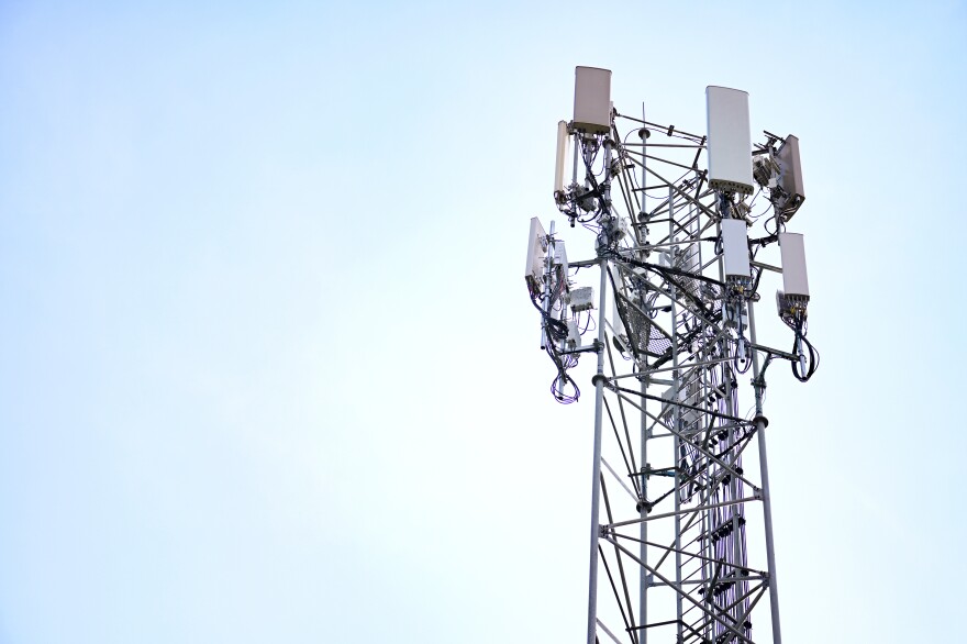 cell tower standing with light blue sky in the background