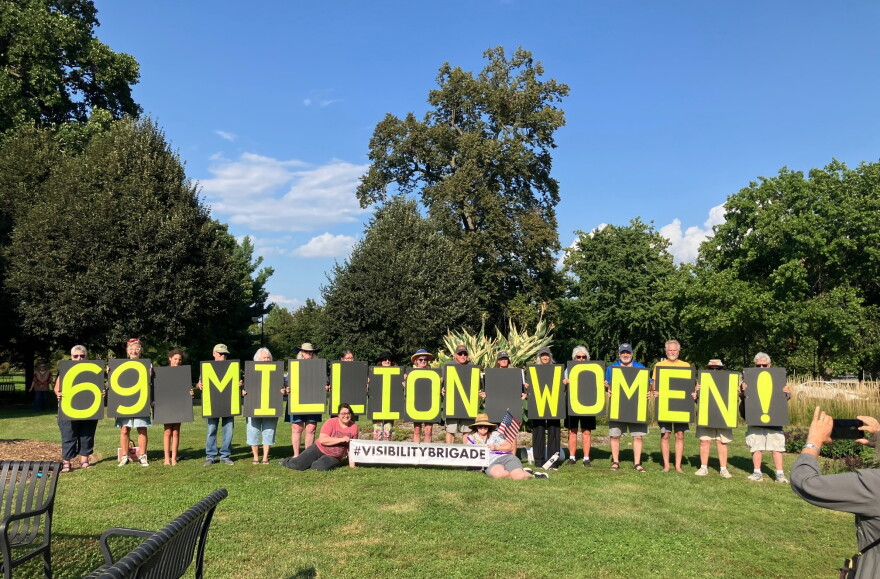 Protestors spell out "69 Million Women," Wednesday at Vander Veer Park, representing the number of U.S. married women who lack a birth certificate that reflects their current name.
