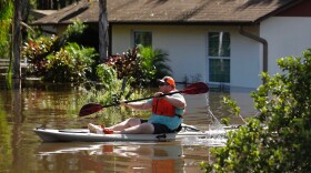 A man paddles a kayak near a flooded home after storm surge from Hurricane Irma pushed water into the low lying area.