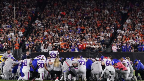 Buffalo Bills players huddle and pray after teammate Damar Hamlin collapsed on the field after making a tackle against the Cincinnati Bengals during the first quarter at Paycor Stadium on Monday in Cincinnati, Ohio.
