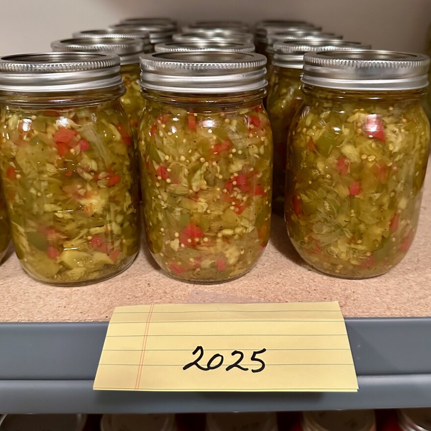 Jars of chow-chow sit on a shelf with a label that reads "2025" 