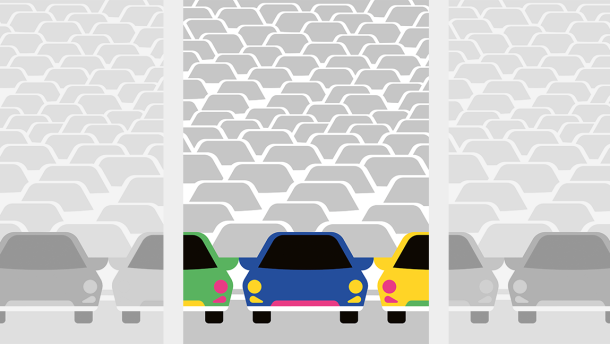 Multi-colored cars sit on an empty car lot. 