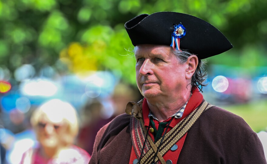 A member of the 24th Connecticut Militia Regiment watches as floral arrangements are placed at the Wyoming Monument.